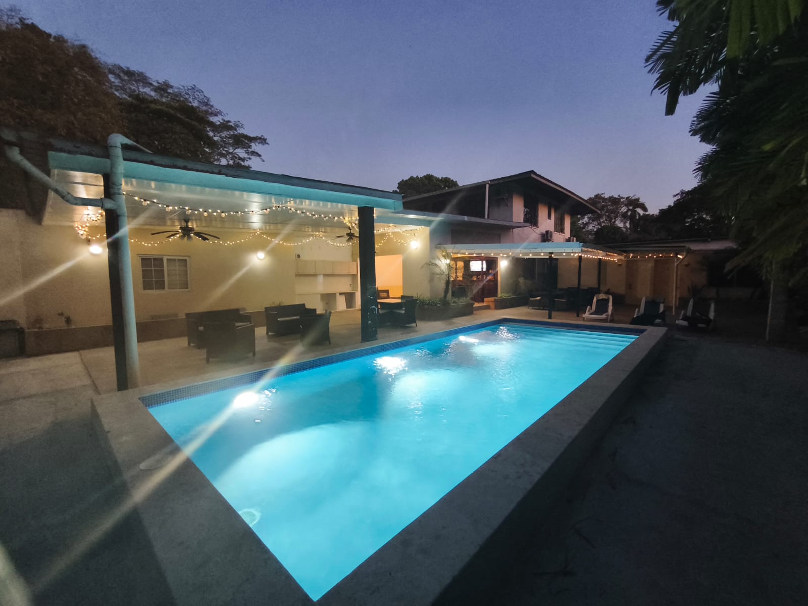 Piscina iluminada al atardecer con fachada de The Balboa Inn boutique hotel en Ciudad de Panamá